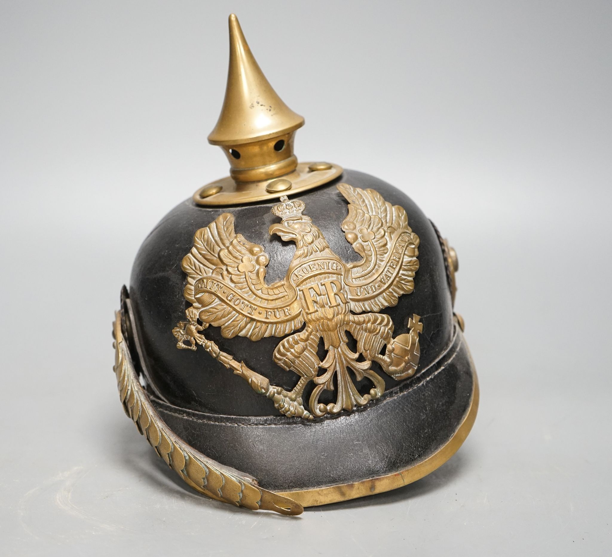 A WW1 Prussian pickelhaube, the leather skull with brass spiked top and eagle plate